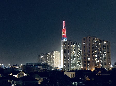 ベトナムの夜景と高層ビルにベトナムの国旗がライトアップ