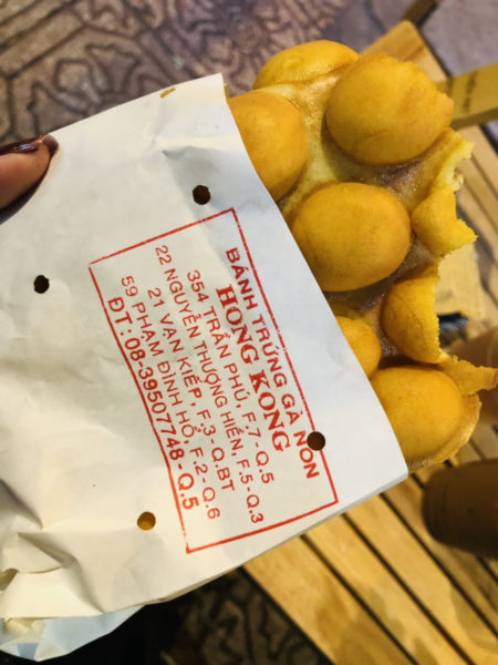 店の住所が印字された紙袋と食べかけのエッグワッフル