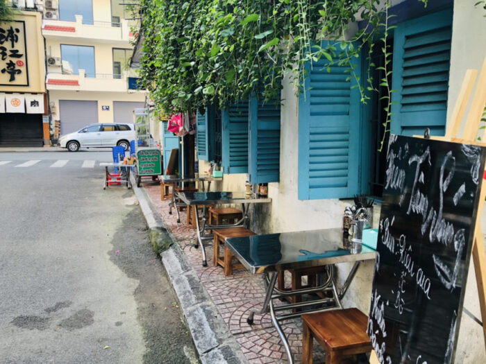 青い窓が特徴的なベトナムの街角の路上カフェ